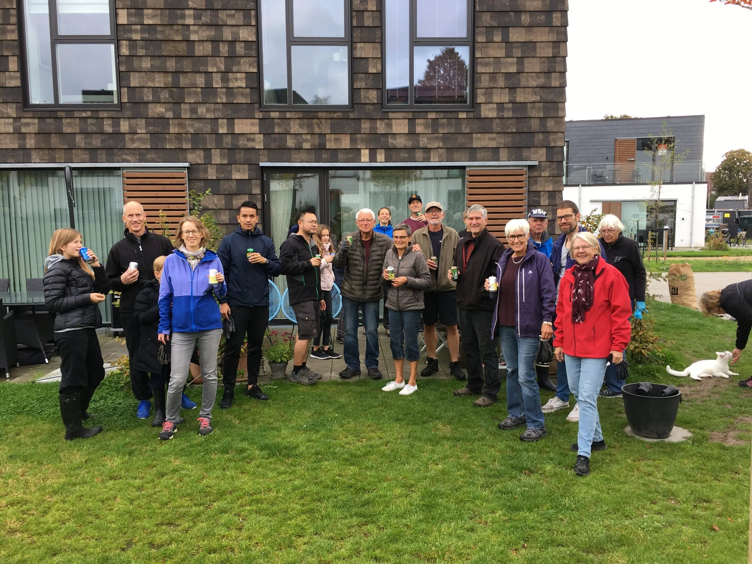 Beboere samlet til fælles skål med drikkevarer efter arbejdsdag foran rækkehus i Bagsværdlund